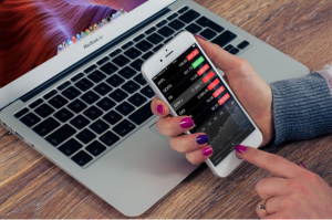 A woman betting on sports online using her phone and computer